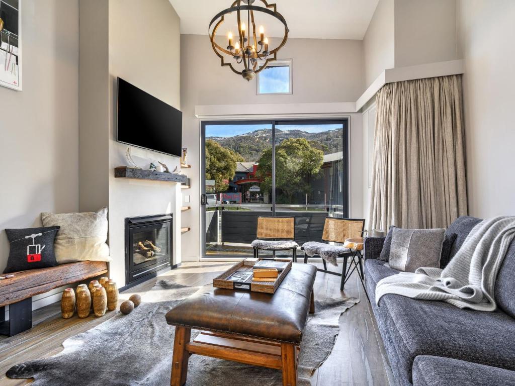 a living room with a couch and a fireplace at Chalet Nanook Akuna 2 in Thredbo
