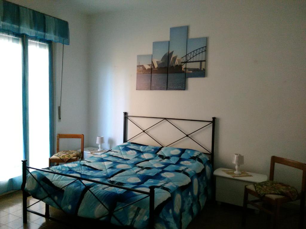 a bedroom with a bed with a blue comforter at Costa degli Etruschi in San Vincenzo