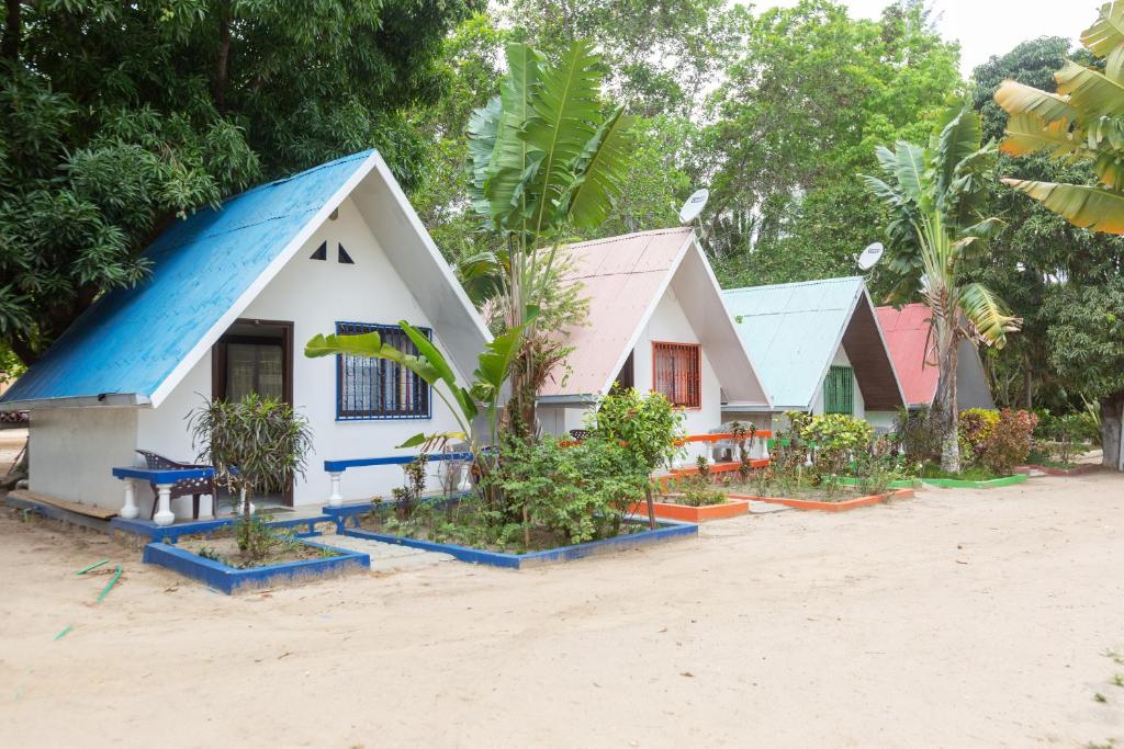 a house with a blue roof on the beach at Holidays Hotel in Mahajanga