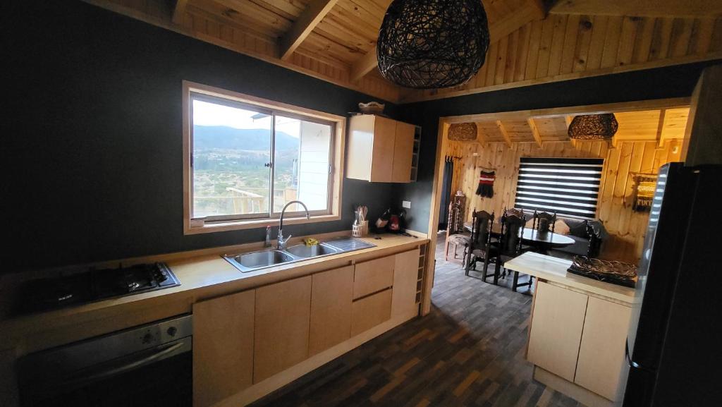 cocina con fregadero y ventana en CABAÑA DE CAMPO, en Cuncumén