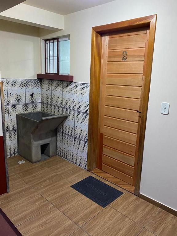 łazienka z drewnianymi drzwiami i kominkiem w obiekcie Hospedaria São José w mieście Treze Tílias