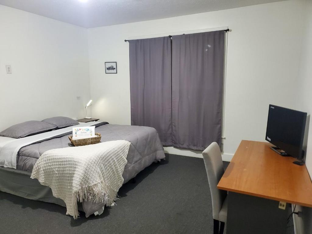 1 dormitorio con 1 cama y escritorio con ordenador en Private Room Near to Downtown Churchill Downs UofL Airport &Kentucky Expo Center, en Louisville