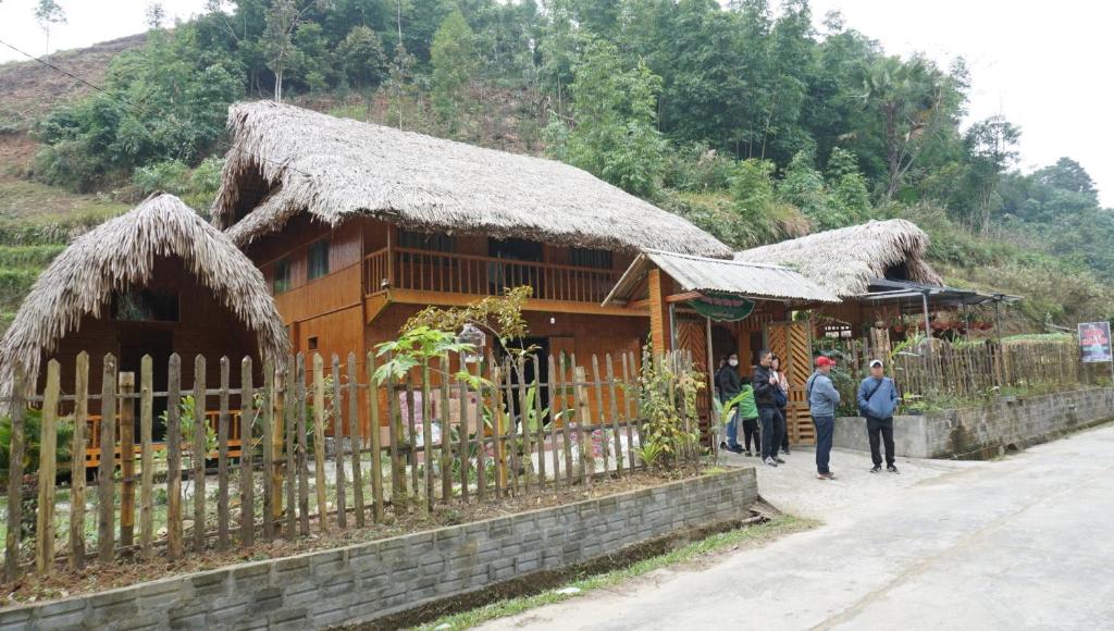 a group of people standing in front of a building at Homestay Khoáng nóng Thông Nguyên in Nam Giang