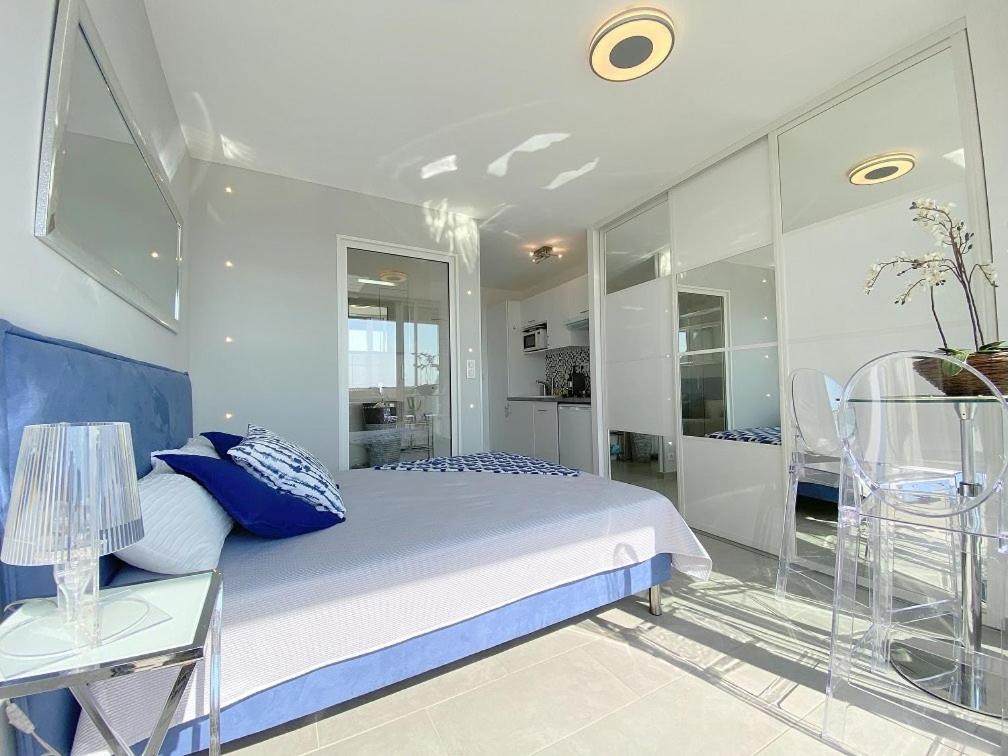 une chambre avec un lit et une paroi vitrée dans l'établissement Cap d'agde Naturiste Heliopolis AB Vue Mer, au Cap d'Agde