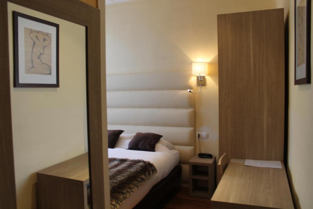 Postel nebo postele na pokoji v ubytování Hotel Napoléon