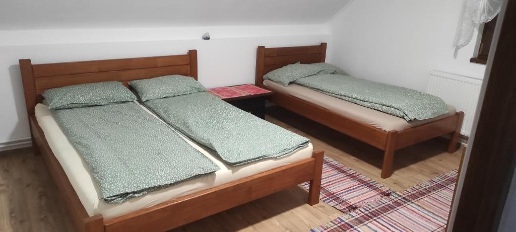 two twin beds in a room with a rug at KANYARalo erdei vendeghaz in Liban