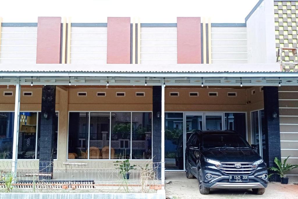 a car parked in front of a building at RedDoorz Syariah Near Danau Tes Bengkulu in Tes