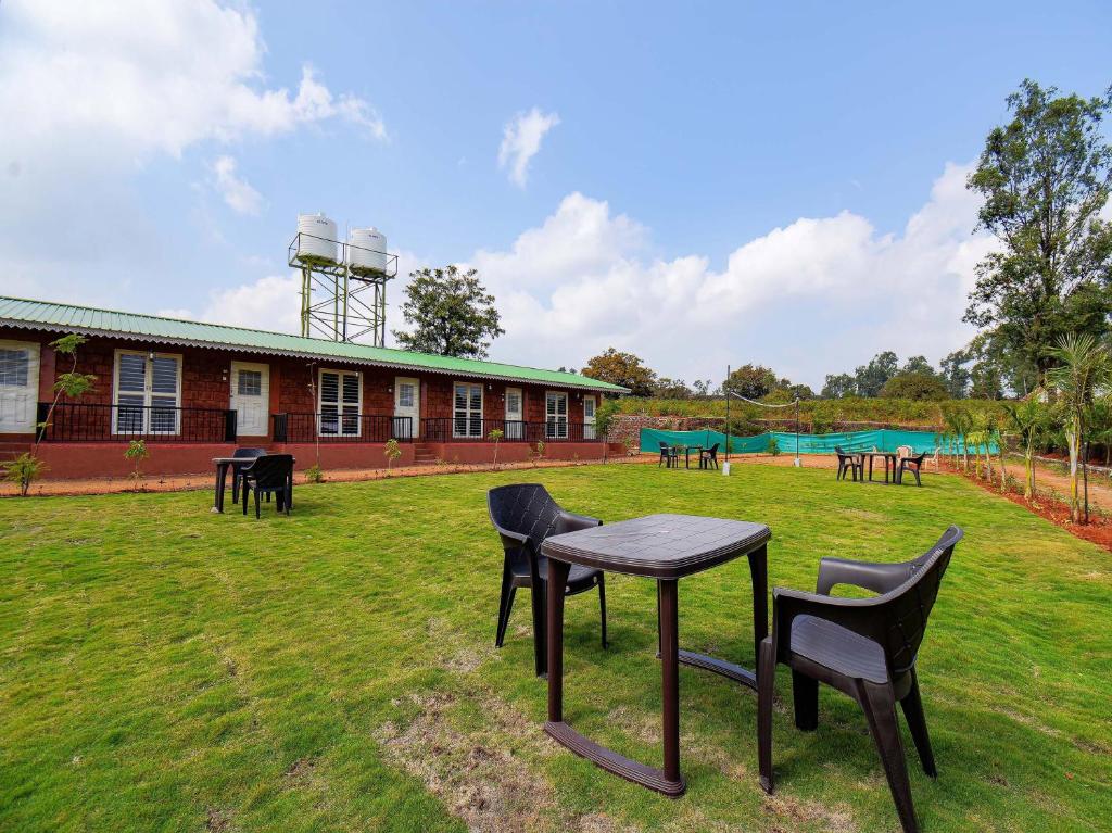 a group of chairs and a table in a yard at Treebo Trend The Appa'S Resort in Mahabaleshwar