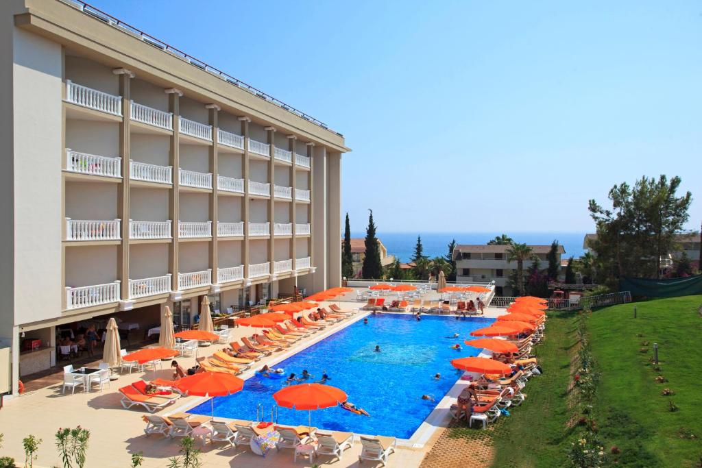 オクルカラールにあるJustiniano Theodora Resortのスイミングプール、オレンジのパラソルが備わるホテルです。