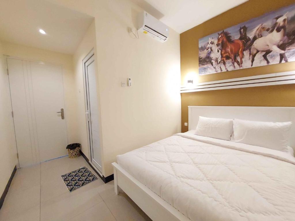 Postel nebo postele na pokoji v ubytování Rons City Hotel near Simpang Lima Semarang Mitra RedDoorz