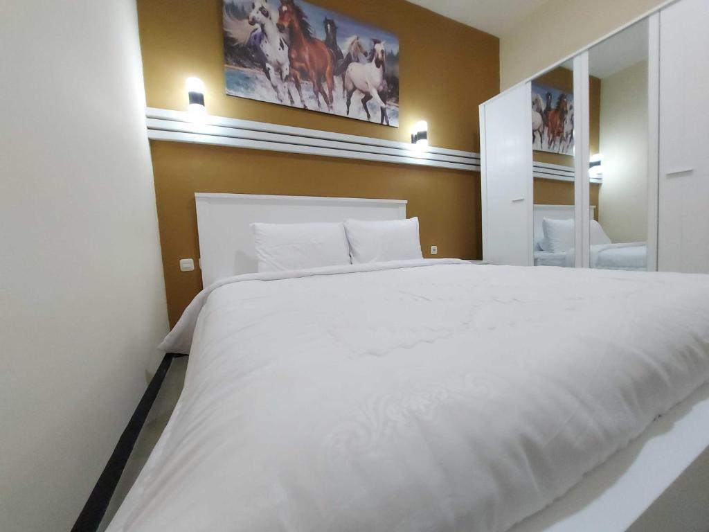 Postel nebo postele na pokoji v ubytování Rons City Hotel near Simpang Lima Semarang Mitra RedDoorz