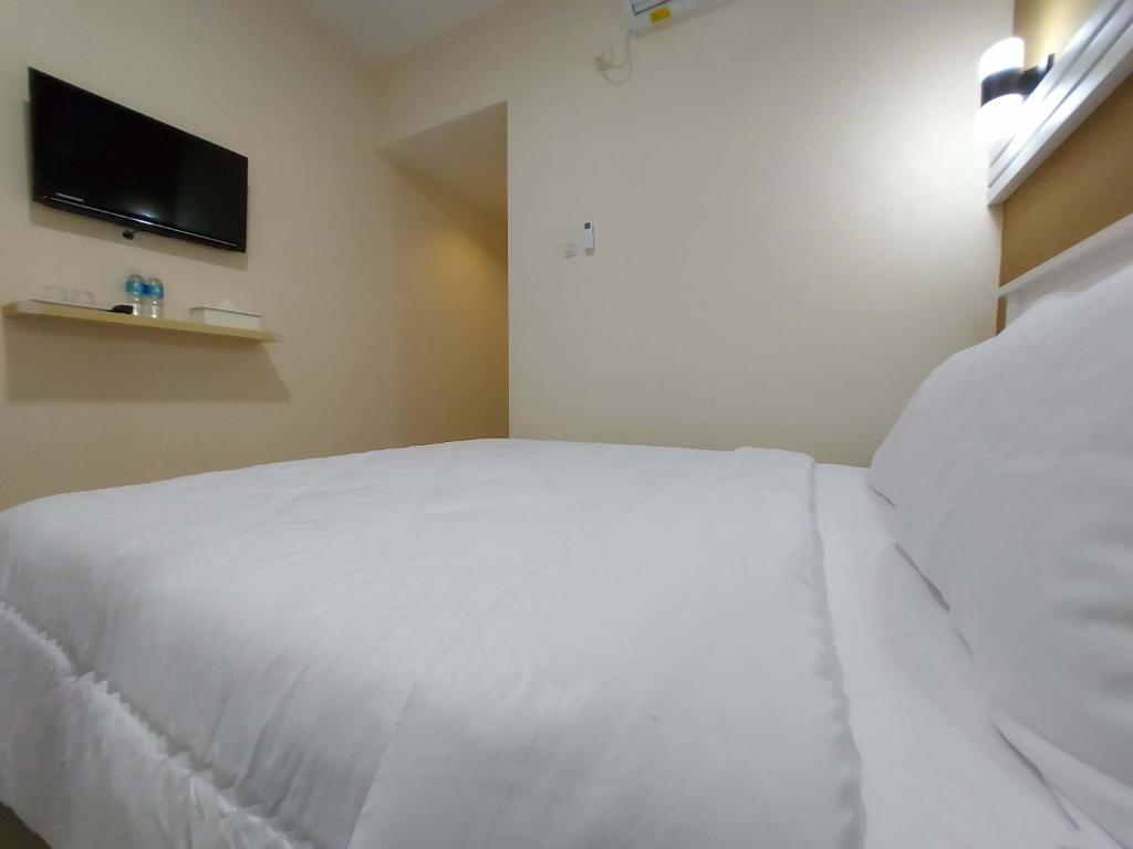 Postel nebo postele na pokoji v ubytování Rons City Hotel near Simpang Lima Semarang Mitra RedDoorz