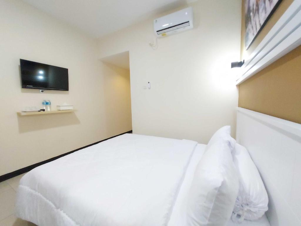Postel nebo postele na pokoji v ubytování Rons City Hotel near Simpang Lima Semarang Mitra RedDoorz