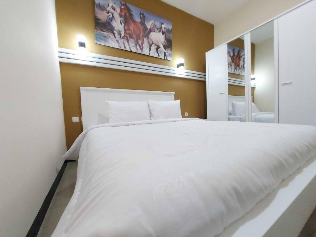 Postel nebo postele na pokoji v ubytování Rons City Hotel near Simpang Lima Semarang Mitra RedDoorz