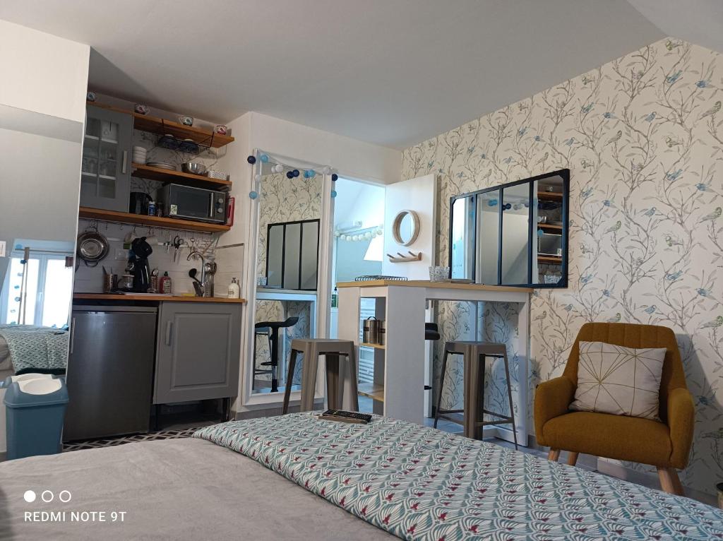 um pequeno quarto com uma cama e uma cozinha em Très beau studio Climatisation, Trois Etoiles, WiFi, Vélos en option, Parking Privé Jardin em Montargis