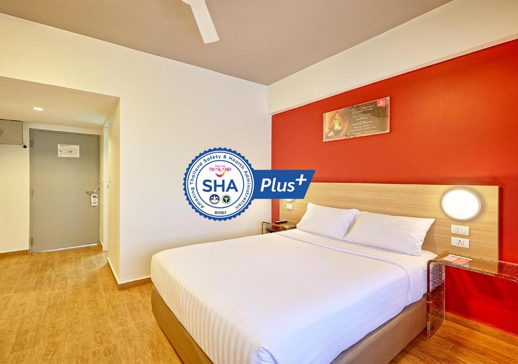 um quarto com uma cama grande e uma parede vermelha em Red Planet Hat Yai SHA extra plus em Hat Yai