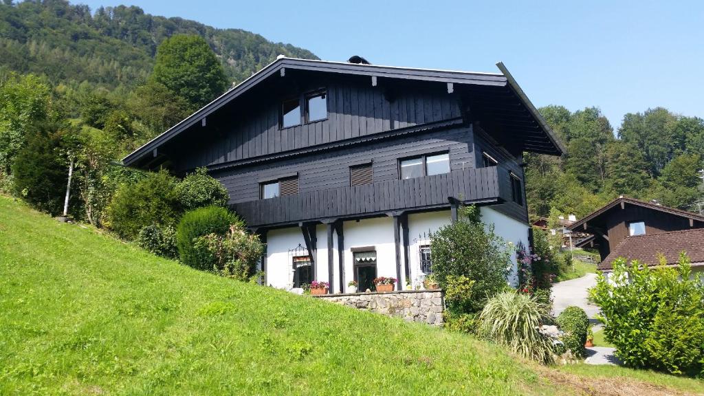 a black and white house on a hill at Ferienwohnung Hergesell in Marktschellenberg