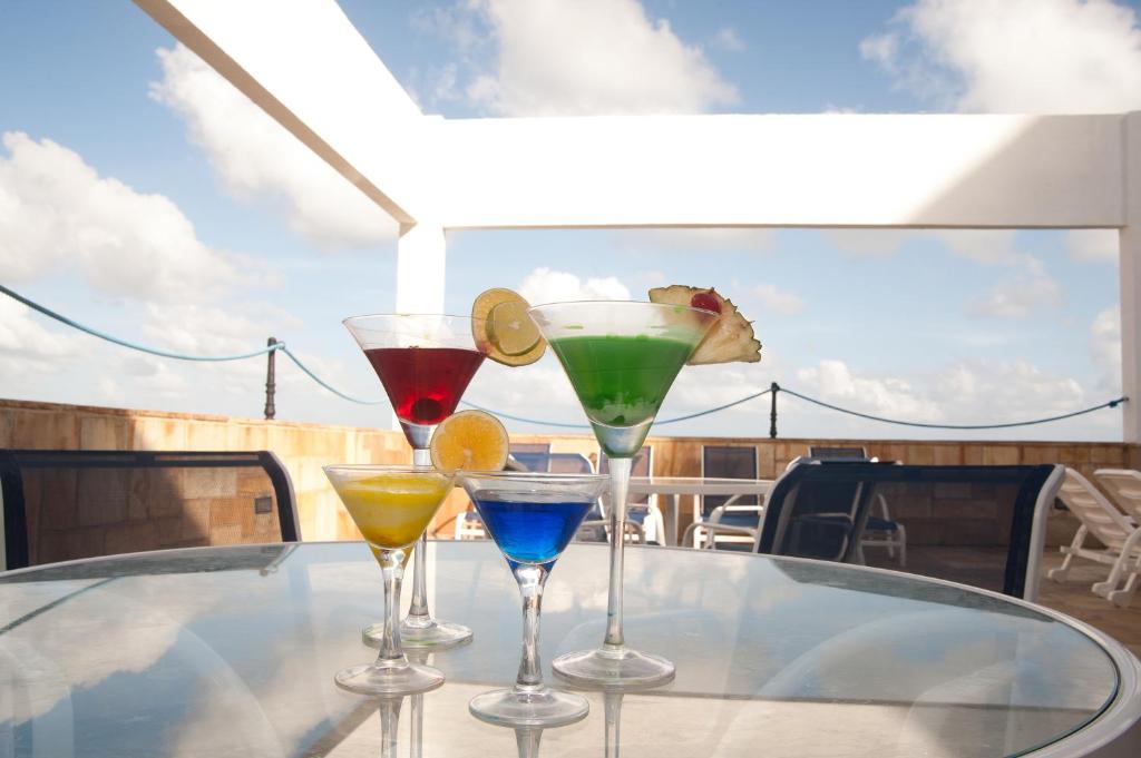 four cocktails sitting on a table on a yacht at Hotel Jangadeiro in Recife