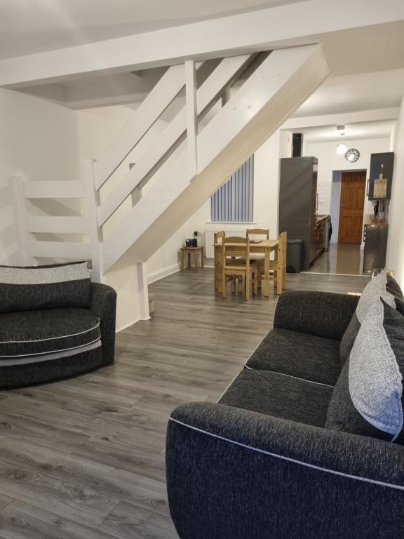 a living room with two couches and a dining room at Spacious and Modern Town House close to The Lake District in Barrow in Furness