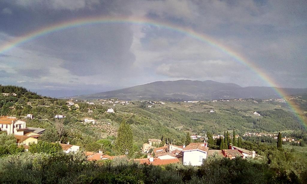 a rainbow in the sky over a town with a city at Fiesole is Magic in Fiesole