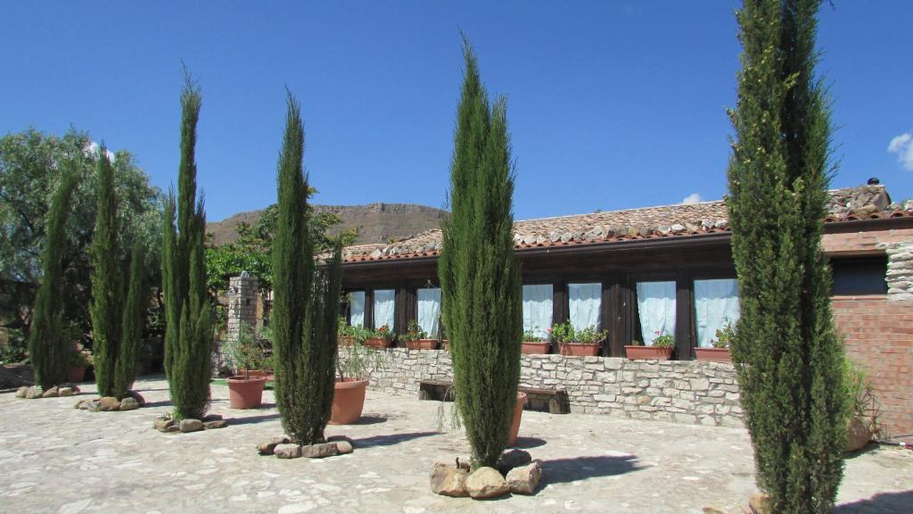 a row of cypress trees in front of a building at Agriturismo Capuano in Gangi