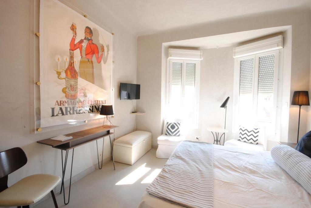- une chambre blanche avec un lit, un bureau et une chaise dans l'établissement Saint ChristopheONI4041, à Cannes