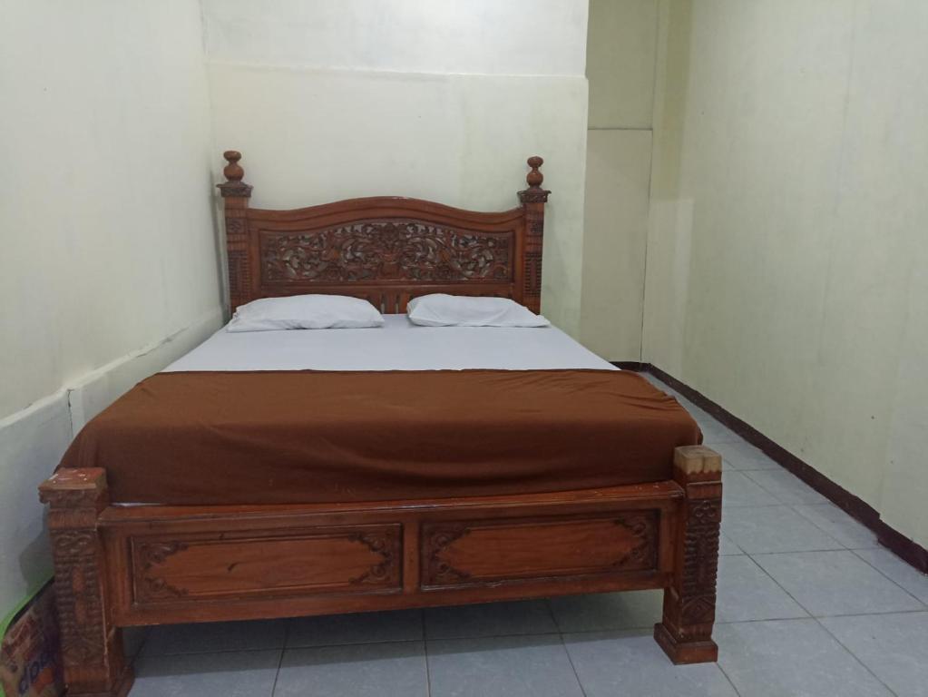 a wooden bed with two pillows on it in a room at Hoya Residence Syariah in Sodong