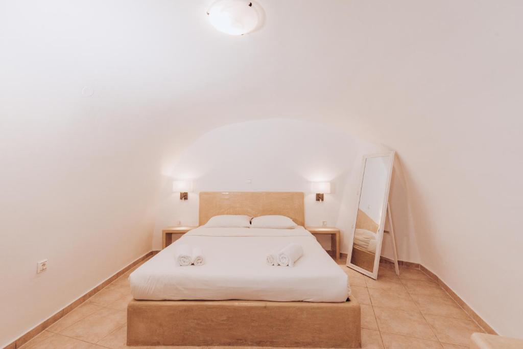 a bedroom with a bed with two towels on it at Gemini Cave in Oia