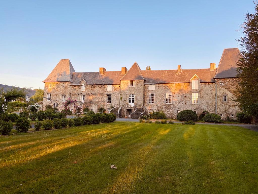 un vieux château avec une grande pelouse dans l'établissement Le Château de la Roque-Logis Hôtels, à Hébécrevon