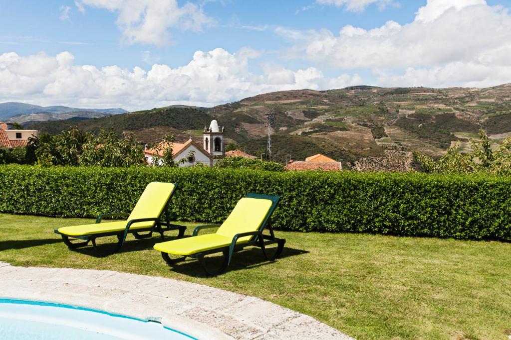 two yellow chairs sitting next to a swimming pool at Douro House Loft in Tabuaço