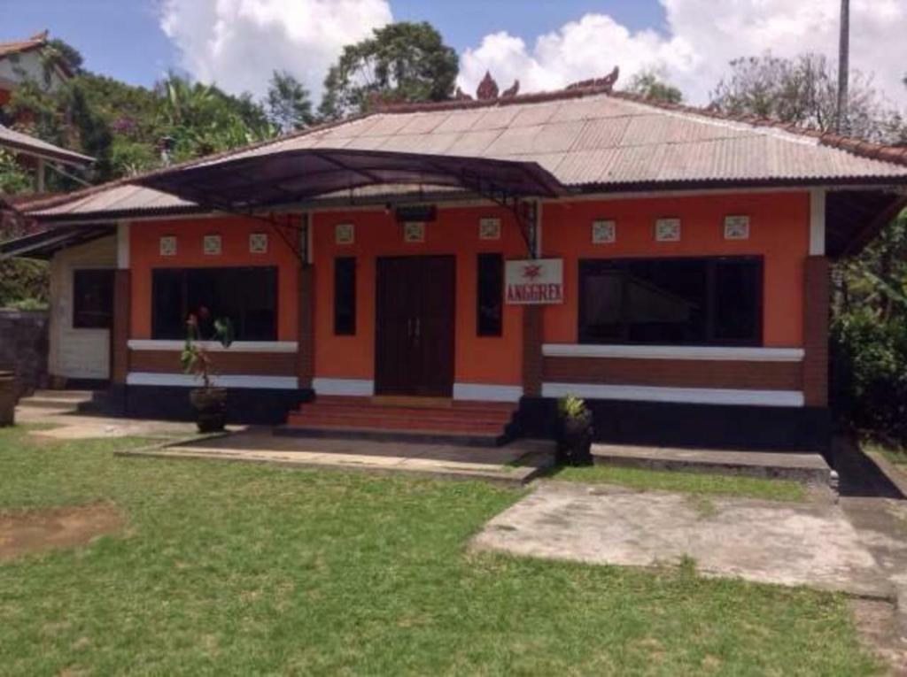 Una pequeña casa naranja con un cartel. en Villa Sinta, en Baturiti
