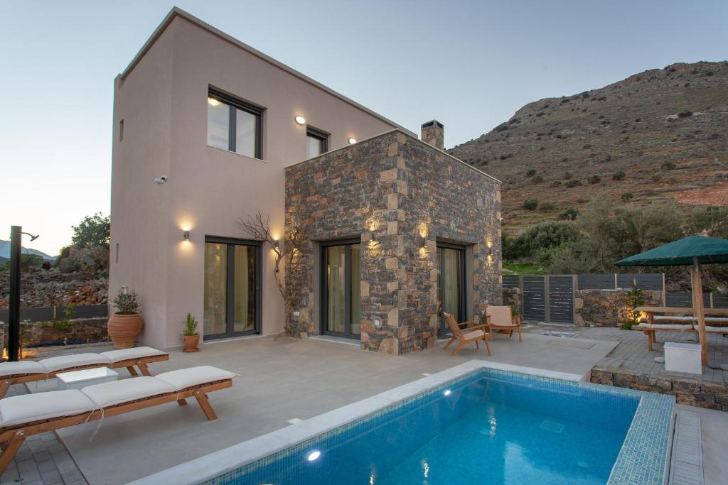 a villa with a swimming pool and a house at Villa Nesea Elounda with private pool in Chavgas