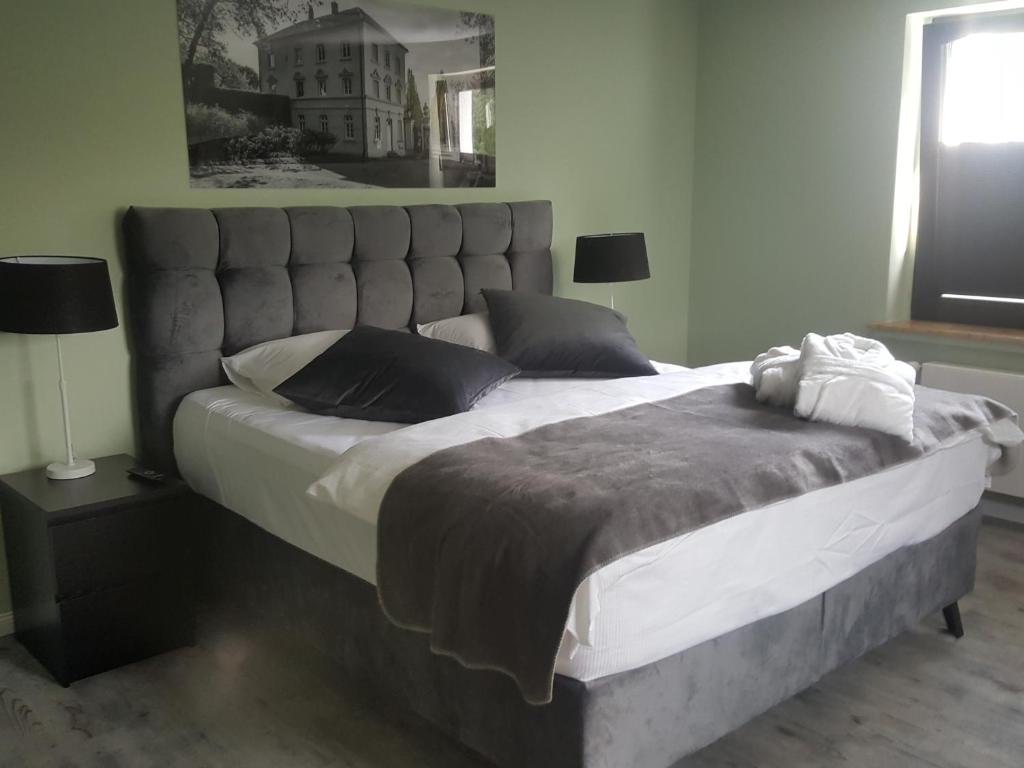 a large bed with a large headboard in a bedroom at Hotel Hilleringmann in Unna