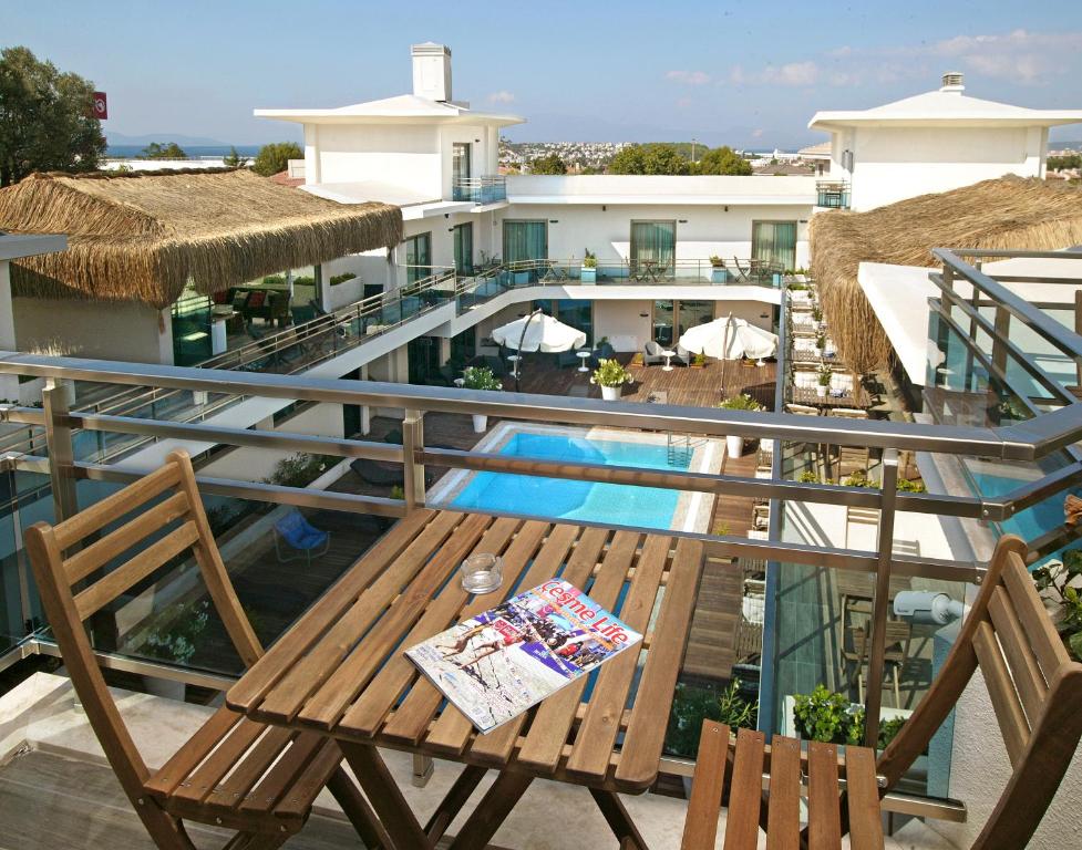 a balcony with a table and chairs and a pool at The D Hotel Çeşme Resort in Çeşme