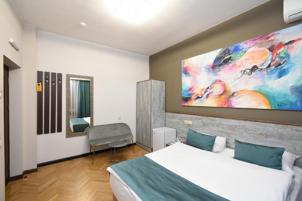 a bedroom with a bed and a large painting on the wall at Yerevan Boutique Hotel in Yerevan