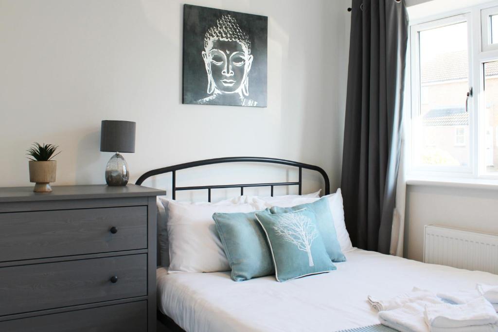 Un dormitorio con una cama con almohadas azules y blancas. en Abingdon - Private Flat with Garden & Parking 06, en Abingdon