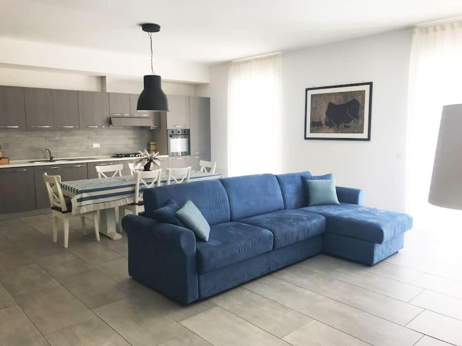 a living room with a blue couch and a kitchen at Silvy House in Terracina