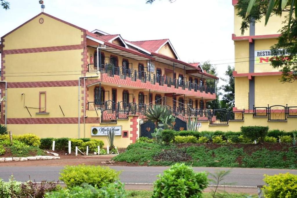 a yellow building with balconies on the side of it at Mpeta House in Nyeri