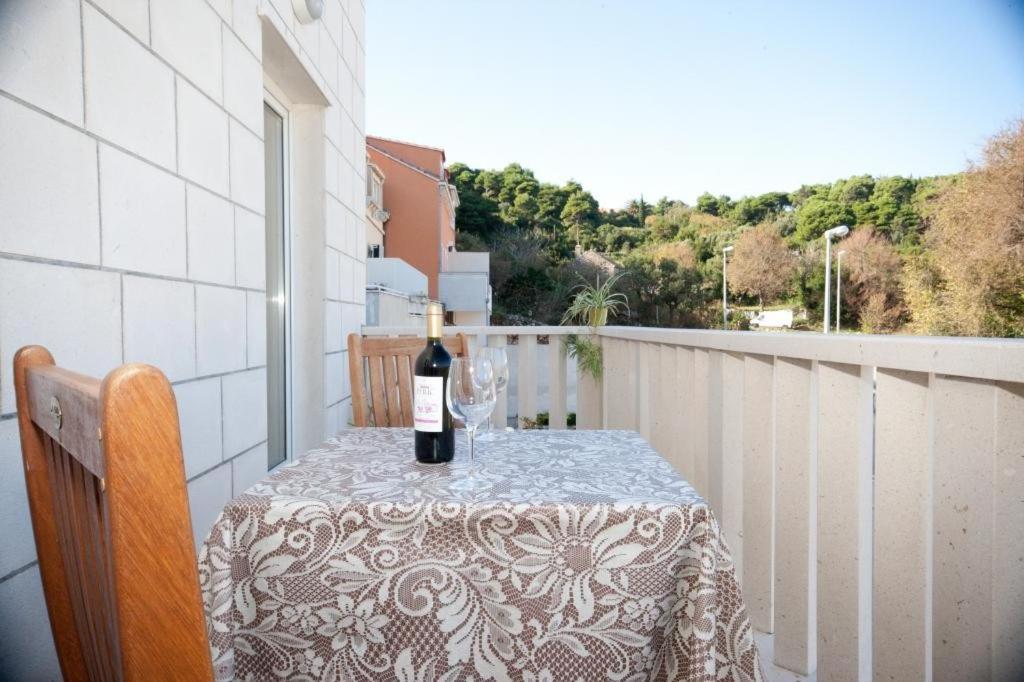 Una botella de vino sentada en una mesa en un balcón en Apartments Briest, en Dubrovnik