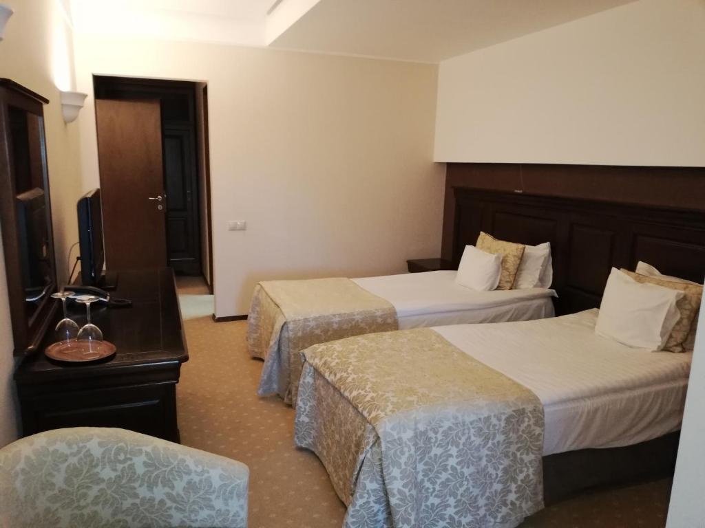 um quarto de hotel com duas camas e uma televisão em Hotel ALPIN - apartament 704 em Poiana Brasov