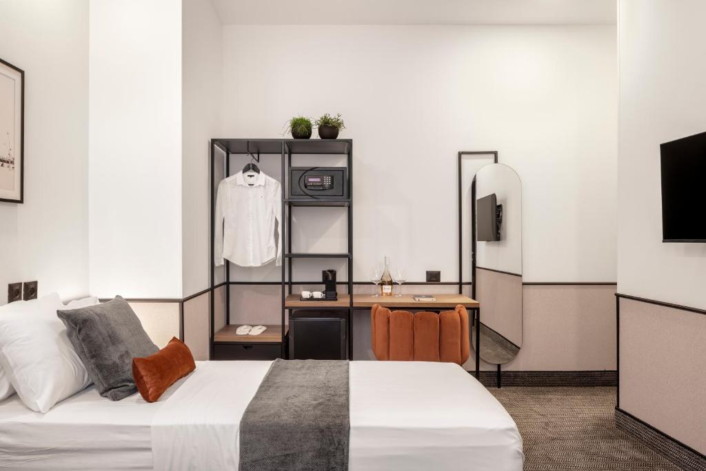 a bedroom with a bed and a desk and a tv at The New Port Hotel TLV in Tel Aviv