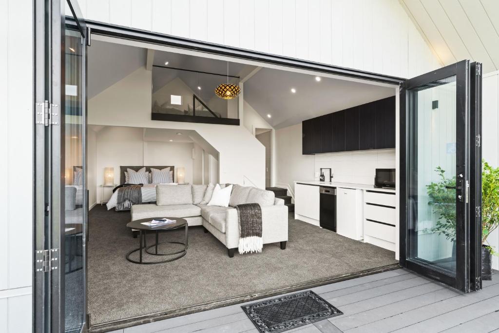 a living room with a couch and a kitchen at The Ridge in Mangawhai