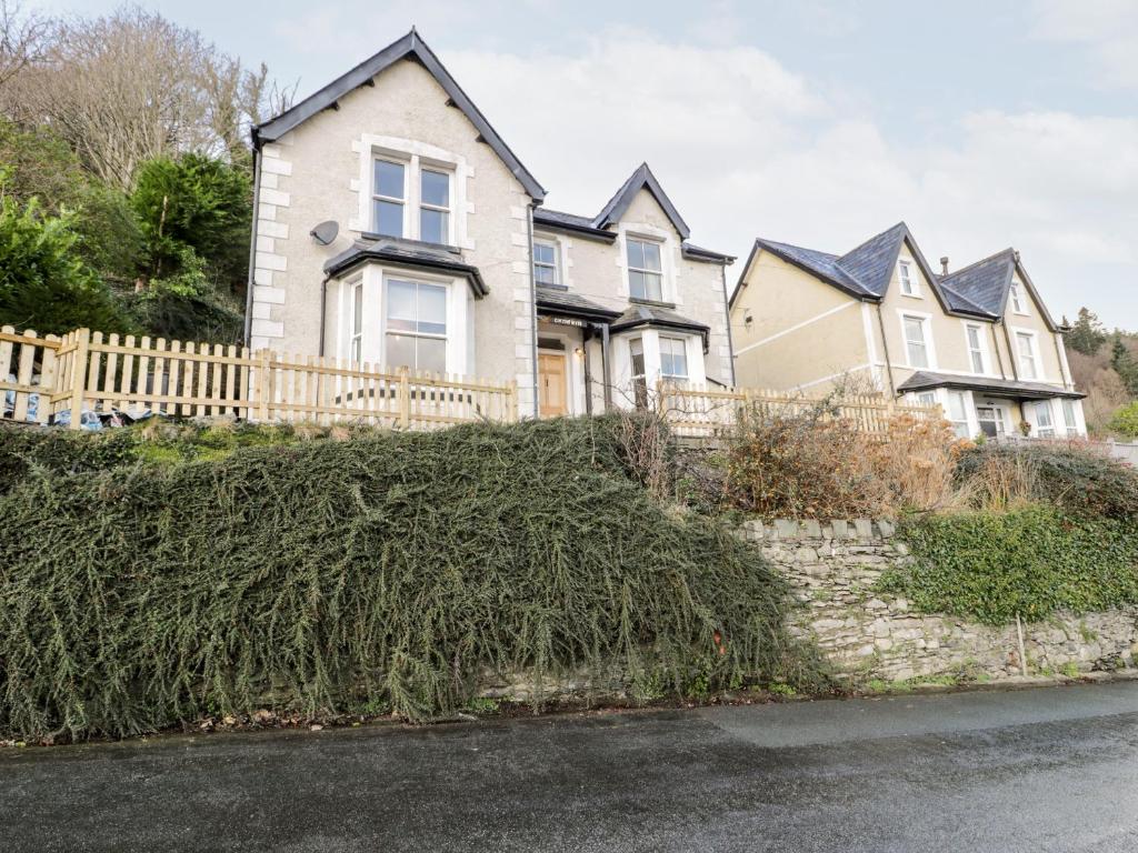 a house with a hedge in front of it at Gwynfryn in Trefriw