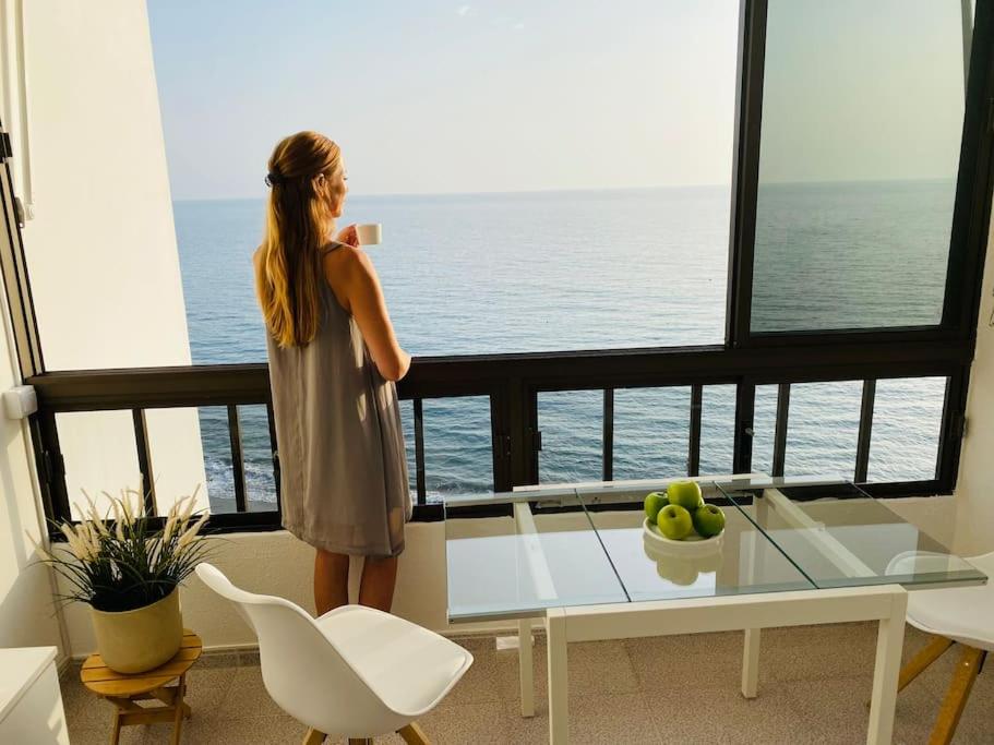een vrouw die een foto van de oceaan neemt vanaf een balkon bij Beach Apartment 8 by SunHousesCanarias in Patalavaca