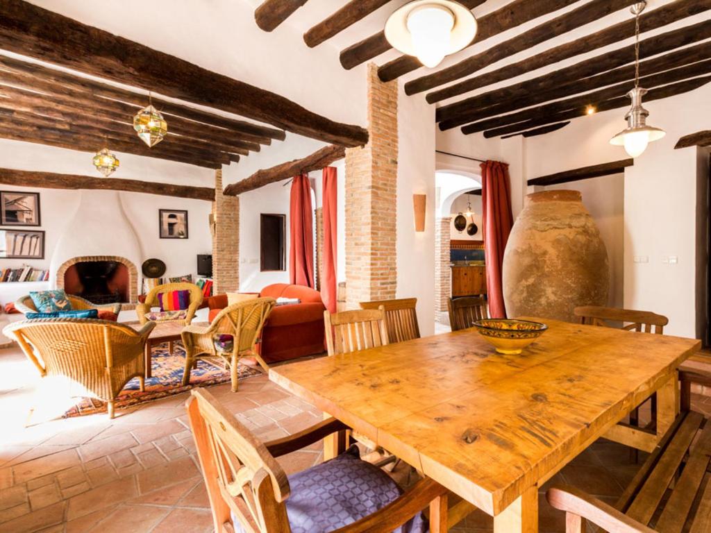 ein Wohnzimmer mit einem Holztisch und Stühlen in der Unterkunft Casa dos tinajas in Pinos del Valle