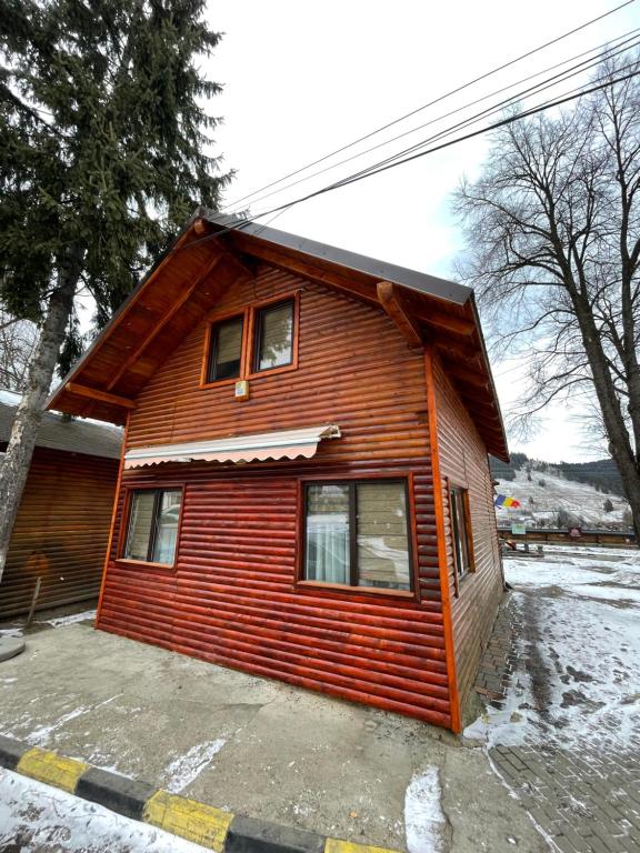 a small wooden house in the snow at ApartElim in Mănăstirea Humorului