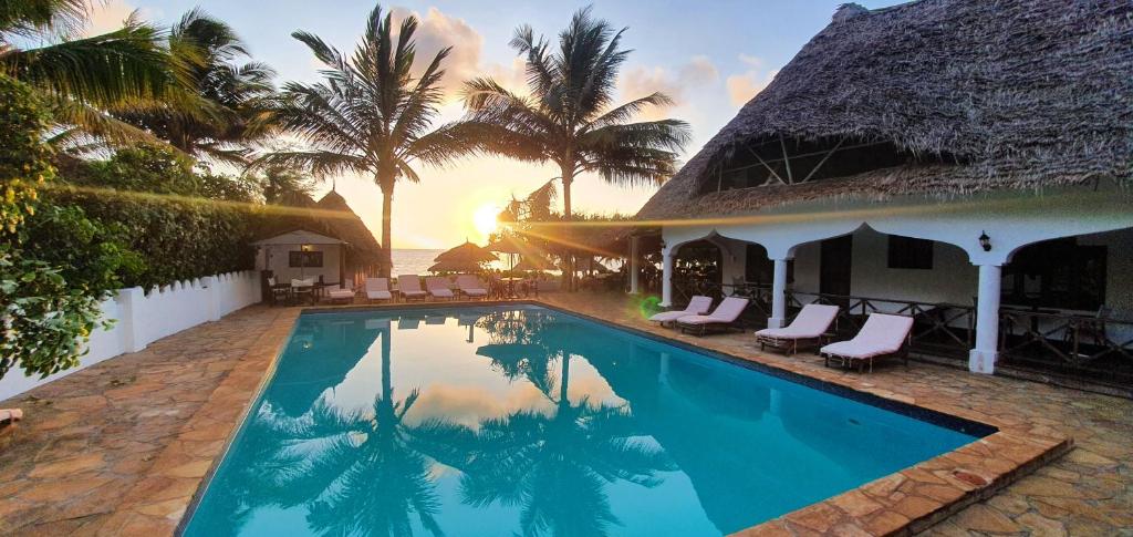a villa with a swimming pool and palm trees at Zanzibar Retreat Hotel in Matemwe
