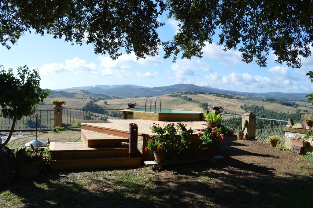 a wooden bench with a pool in a yard at Agri-Bio Podere Santa Palmira in Pomarance
