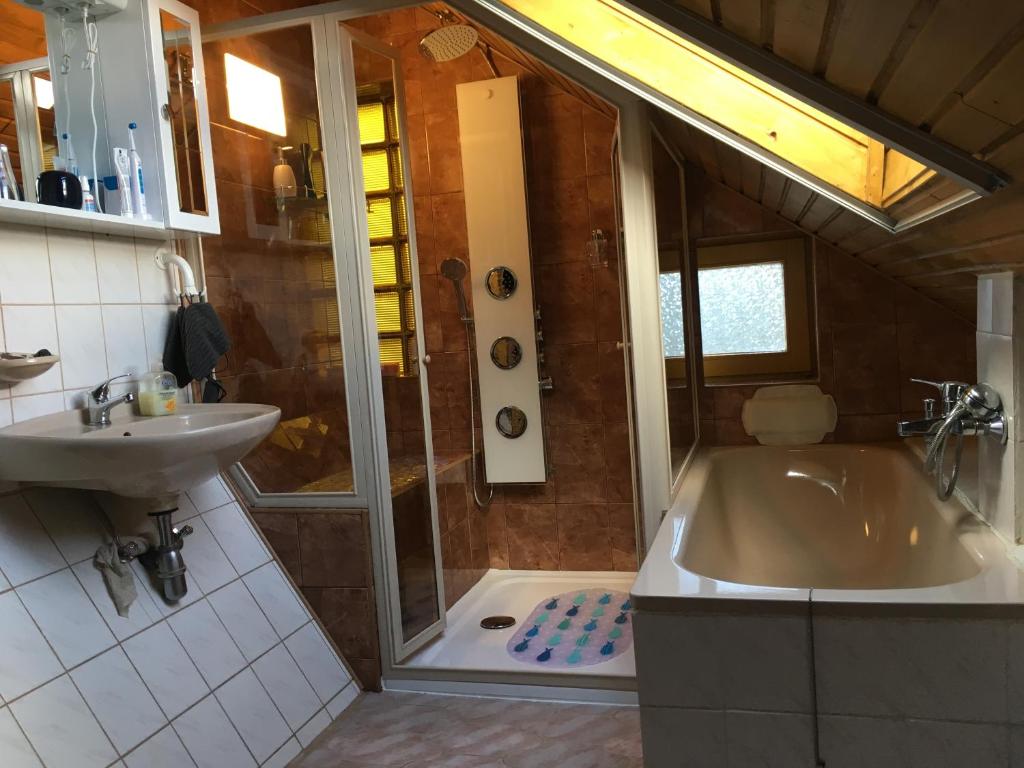 łazienka z prysznicem, wanną i umywalką w obiekcie Aktiv pihenés apartman w mieście Révfülöp