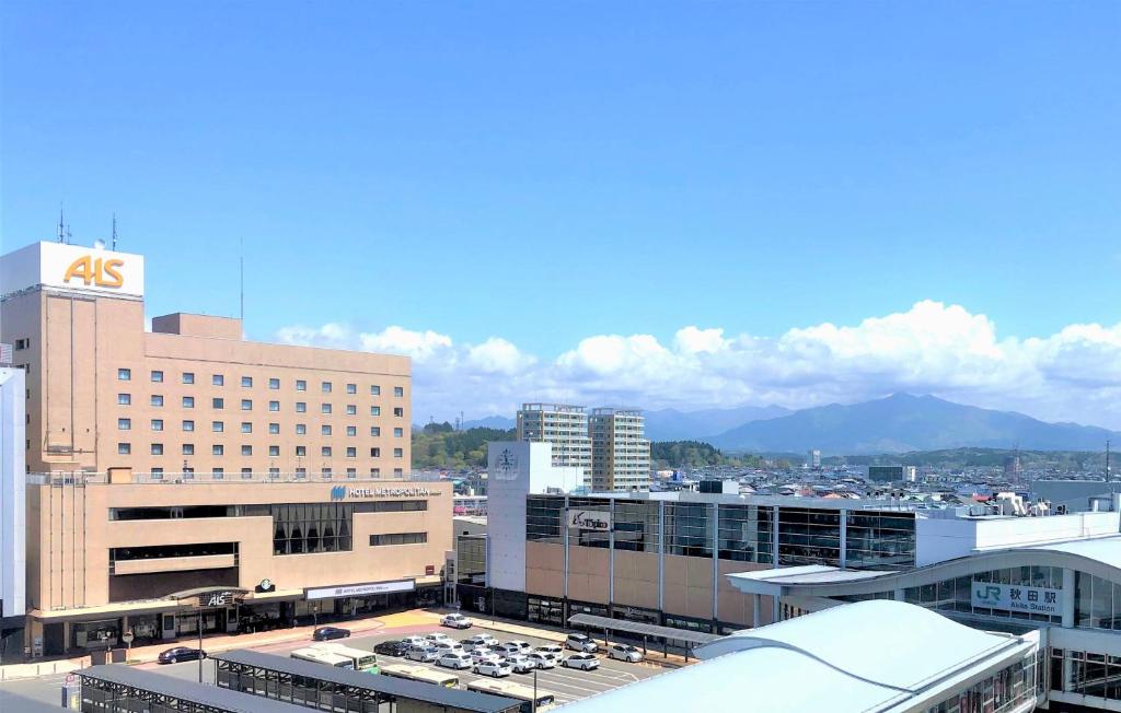 Vue aride d'une ville avec des bâtiments et des montagnes dans l'établissement Hotel Metropolitan Akita, à Akita